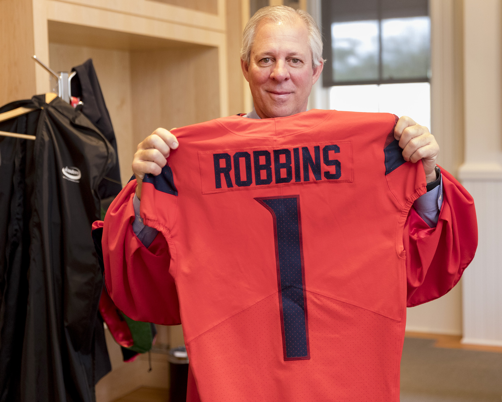 President Robbins holds up #1 football jersey