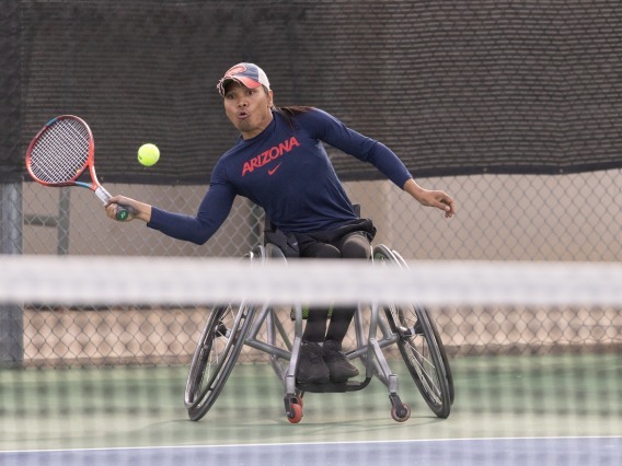 Den Baseda hitting a tennis abll in a wheelchair tennis match