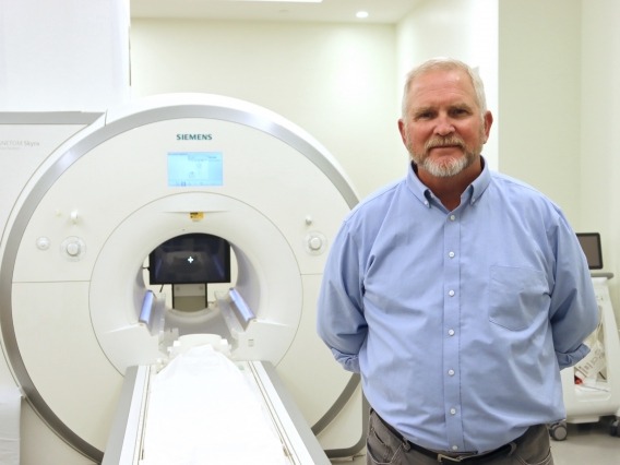 Ted Trouard standing next to an advanced MRI machine