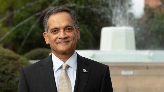 President Garimella wearing a dark colored suit with a fountain in the background.