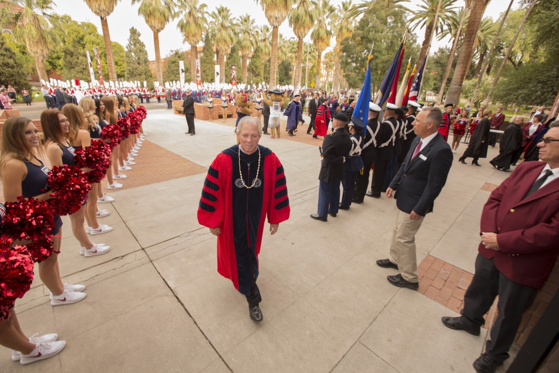 UA 22nd President Robert C. Robbins, welcomed by the Pride of Arizona, the Pom Line and the ROTC Joint Color Guard, follows the Procession into Centennial Hall to start the Installation ceremony.