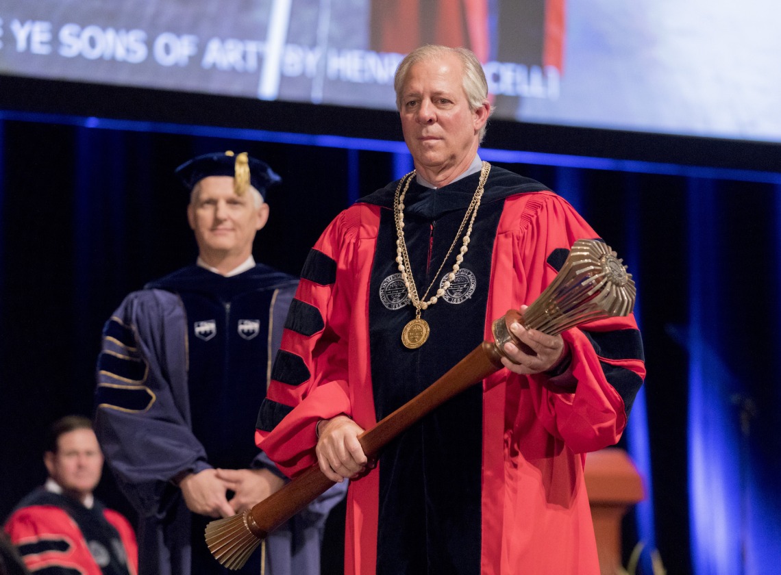 Dr. Robbins, holding the Ceremonial Mace and the President’s Medallion