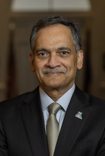 Portrait of President Garimella wearing a blue blazer, tie, and a block A logo lapel pin.